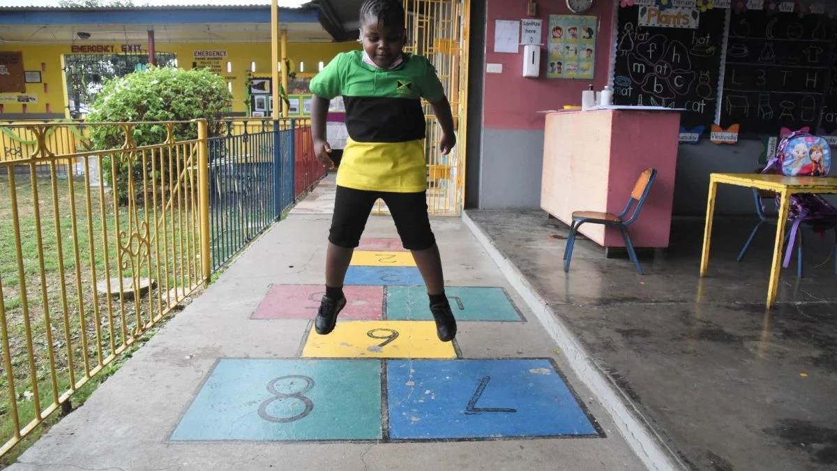 Young Black Jamaican girl playing hopscotch