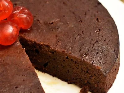 A dark Jamaican black cake, rich with rum-soaked fruit, ready for Christmas