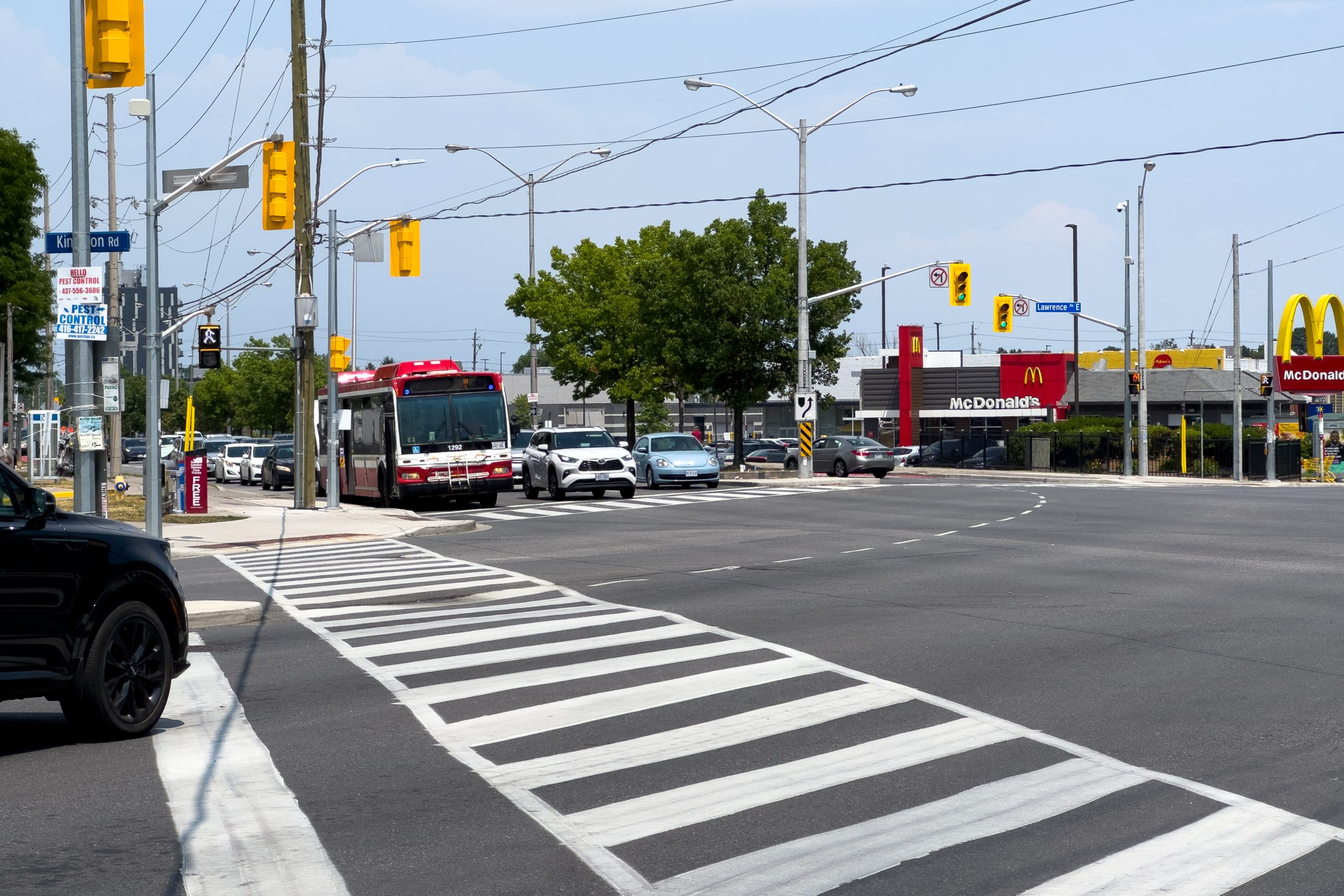 Kingston Road and Lawrence Avenue East intersection in Scarborough, Toronto, with a TTC bus crossing.
