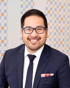 Official portrait of Alvin Tedjo in a suit and glasses